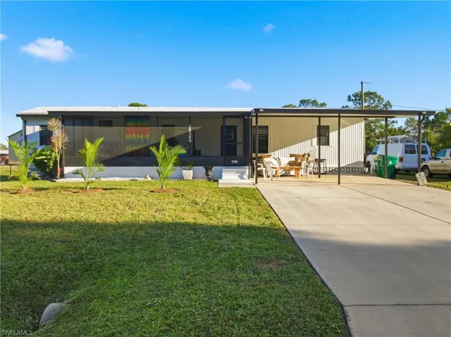 Rear view of property featuring a lawn and a sunroom