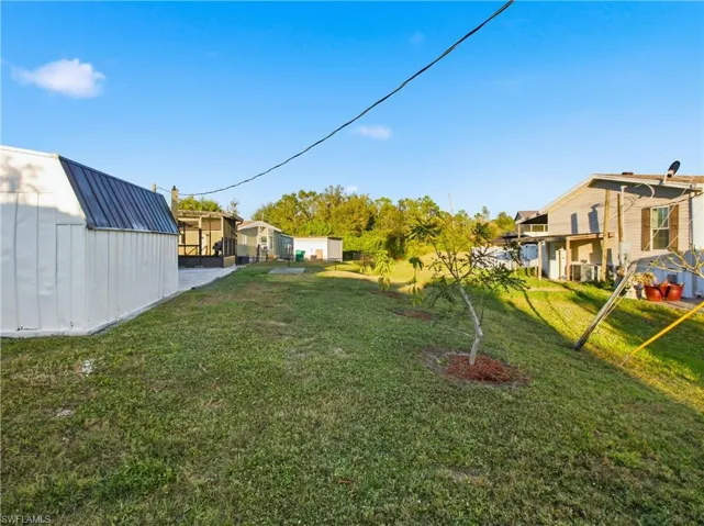 View of green lawn with a shed and a residential view