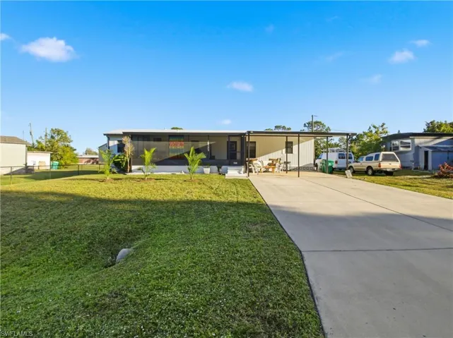 View of front facade featuring driveway and a sunroom