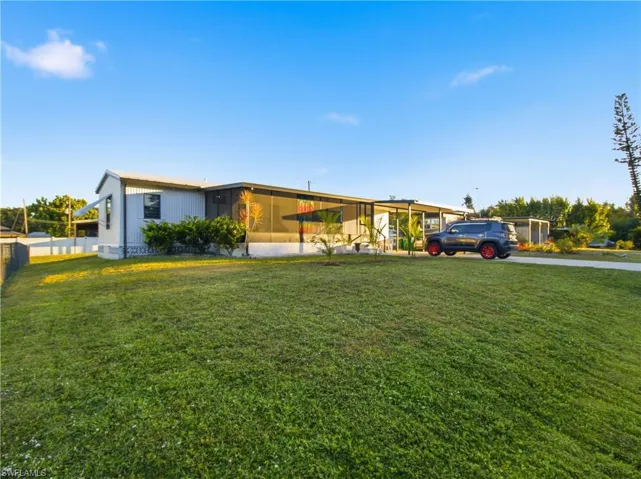 View of front facade featuring a front lawn and a sunroom