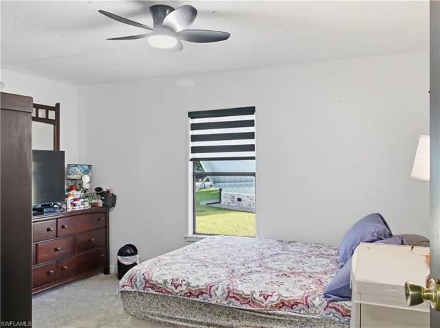 Bedroom with light carpet and a ceiling fan