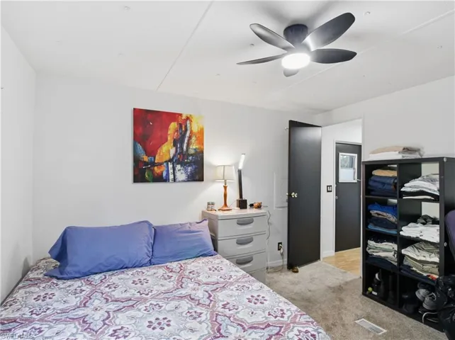 Bedroom with light colored carpet and ceiling fan