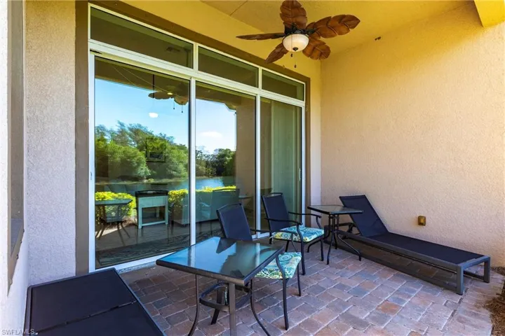 Patio featuring brick paver flooring, a ceiling fan, and sliding glass doors