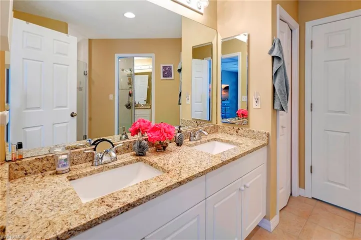 Bathroom featuring dual bowl vanity and tile patterned flooring