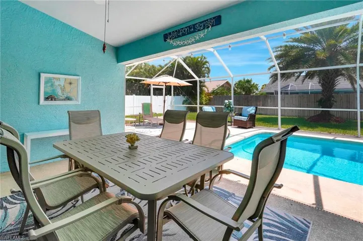 View of pool featuring glass enclosure and a patio area