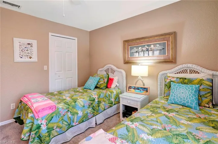 Carpeted bedroom with ceiling fan and a closet