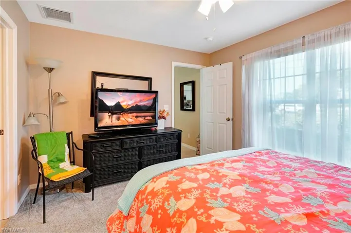 Bedroom with ceiling fan and light colored carpet