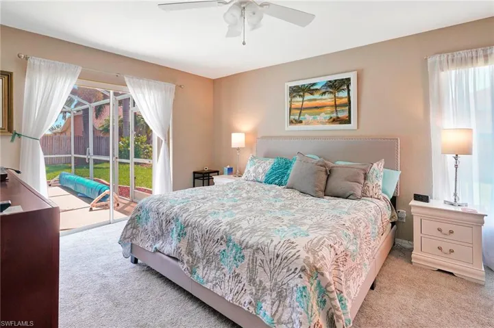 Carpeted bedroom featuring ceiling fan and access to exterior