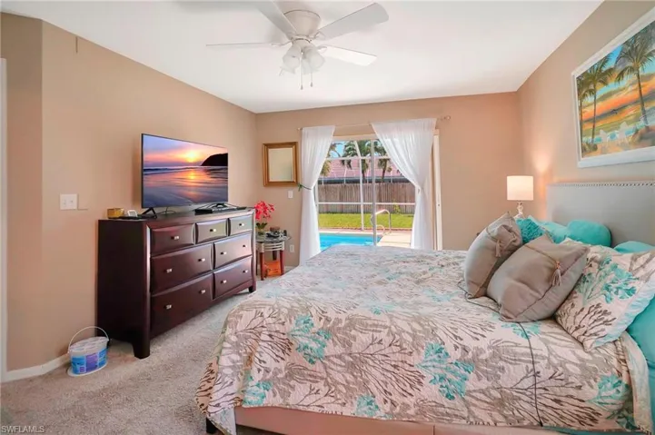 Carpeted bedroom featuring ceiling fan