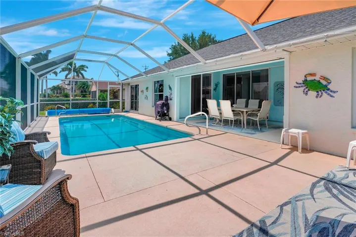 View of swimming pool featuring glass enclosure and a patio area