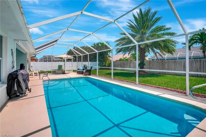 View of swimming pool with glass enclosure, a yard, and a patio area