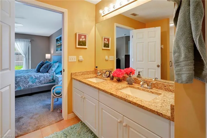 Bathroom featuring tile patterned floors and dual bowl vanity