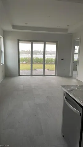 Great room with tray ceiling and impact resistant sliding glass doors