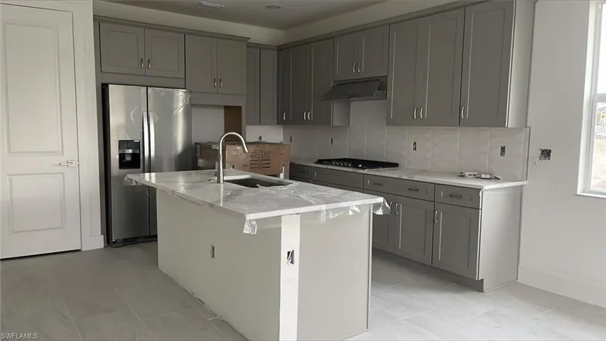 Open-concept kitchen with quartz countertops, stainless steel appliances, soft-close cabinets and drawers