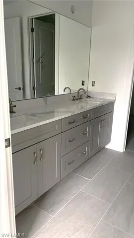 Primary bathroom with quartz countertops, soft-close cabinetry, dual-sinks, and Kohler plumbing