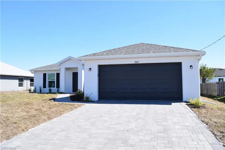 Single story home featuring stucco siding, decorative driveway, a shingled roof, and a garage