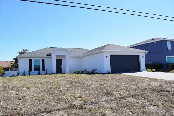 Single story home featuring stucco siding, an attached garage, driveway, and a front lawn