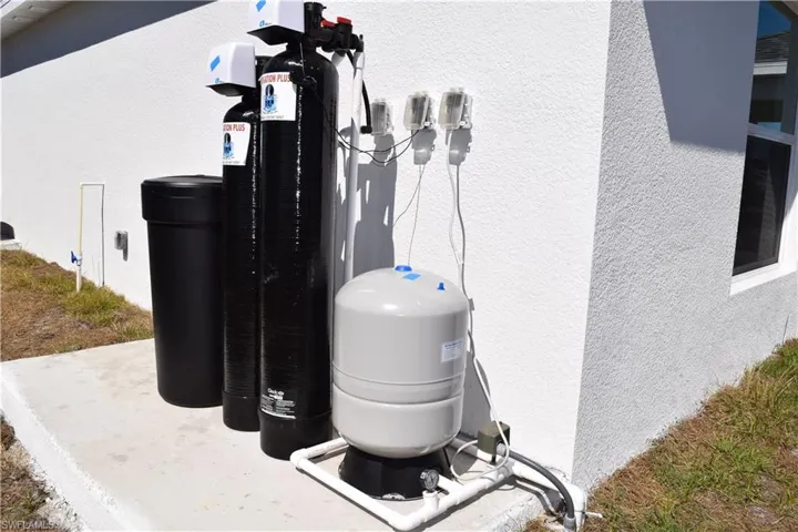 Exterior view of a water softener system and stucco siding