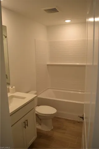 Bathroom featuring vanity, wood tiled floors, and tub / shower combination