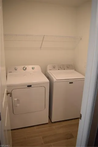 Laundry area with washing machine and dryer and wood finish floors