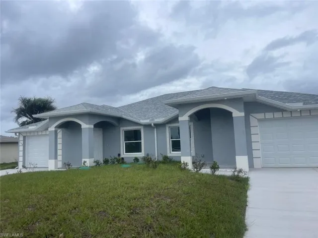 Single story home with a garage and a front yard