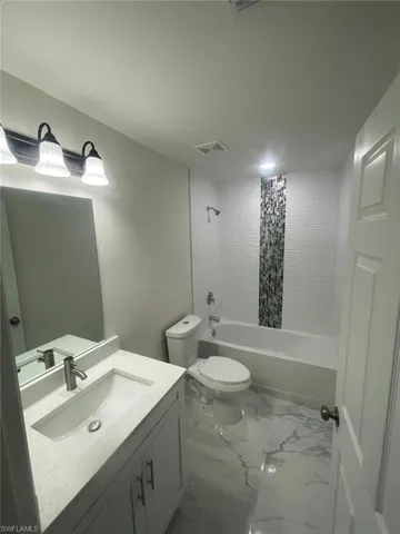 Full bathroom with shower / bath combo, vanity, and toilet