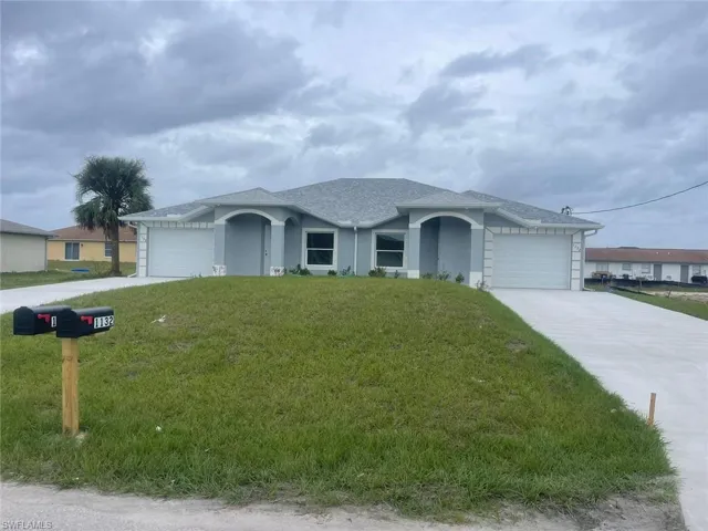 Ranch-style home featuring a garage and a front yard