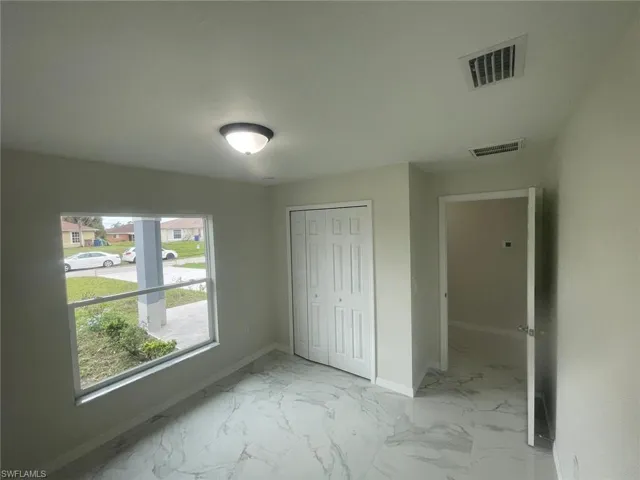 Unfurnished bedroom featuring a closet and multiple windows
