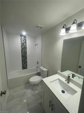 Full bathroom featuring shower / tub combo with curtain, vanity, and toilet