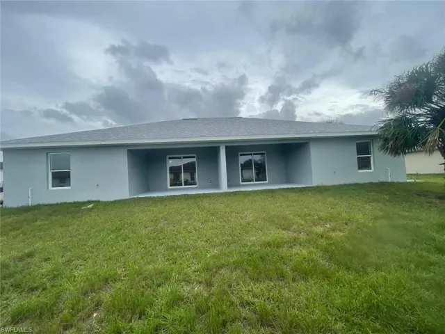 Back of property featuring a lawn