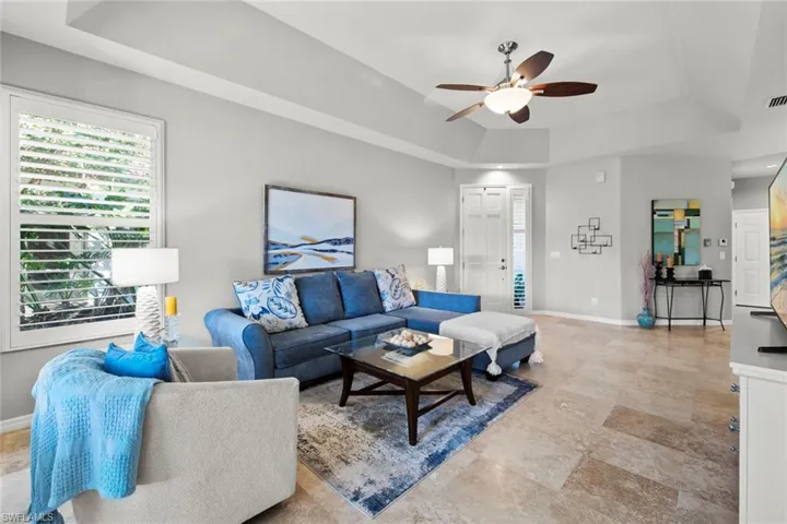 Living room with ceiling fan and a tray ceiling