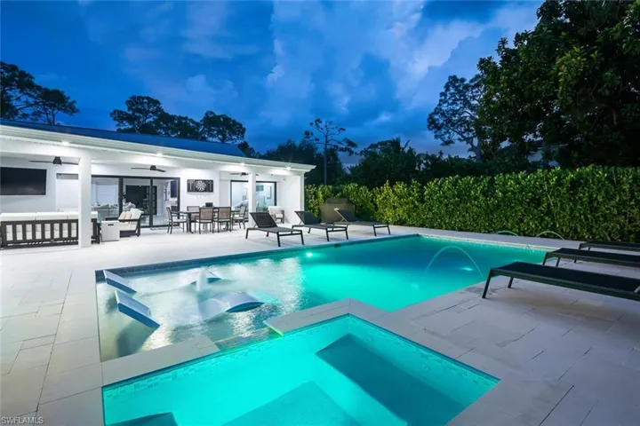 View of pool with spa, a patio area, and pool water feature