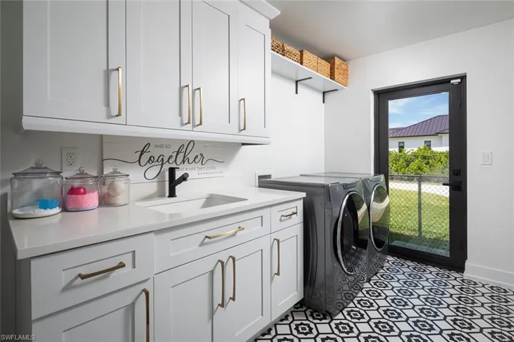 Washroom featuring independent washer and dryer, sink, and cabinets