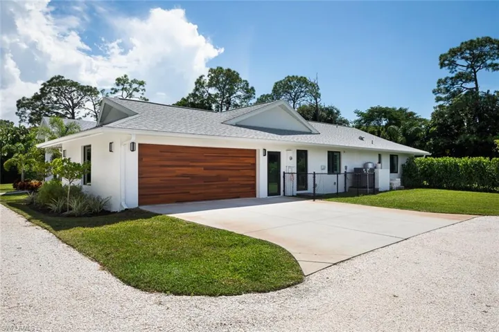 View of front of house with a garage and a front lawn