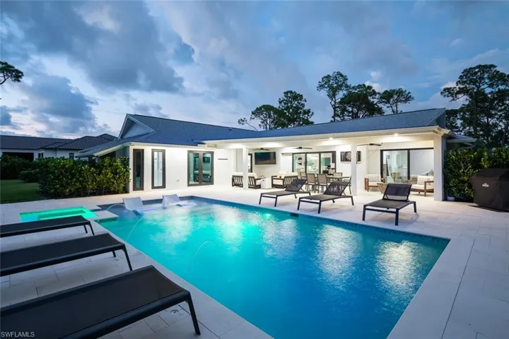 View of pool with ceiling fan, outdoor lounge area, a patio, and pool water feature