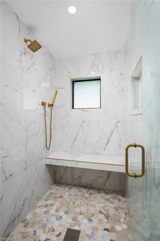 Bathroom featuring a walk in shower with door