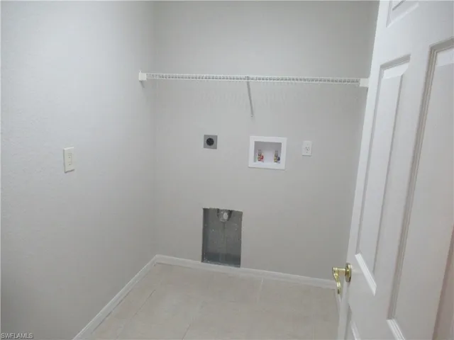 Laundry room featuring hookup for a washing machine, hookup for an electric dryer, and light tile patterned flooring