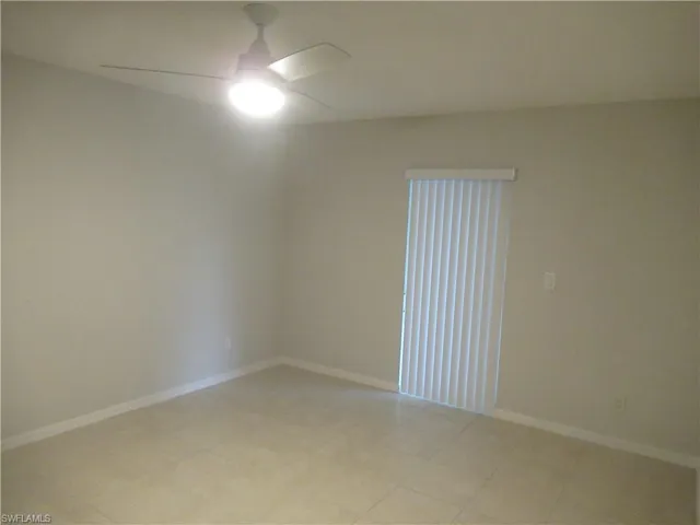 Unfurnished room with ceiling fan and baseboards