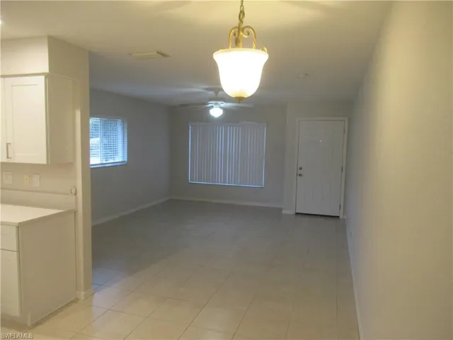 Unfurnished dining area featuring a ceiling fan and light tile patterned floors