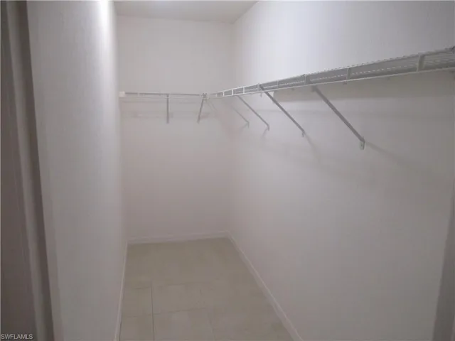 Walk in closet with light tile patterned floors
