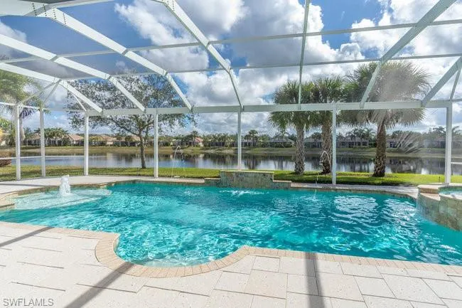View of pool with a patio, pool water feature, a water view, and glass enclosure