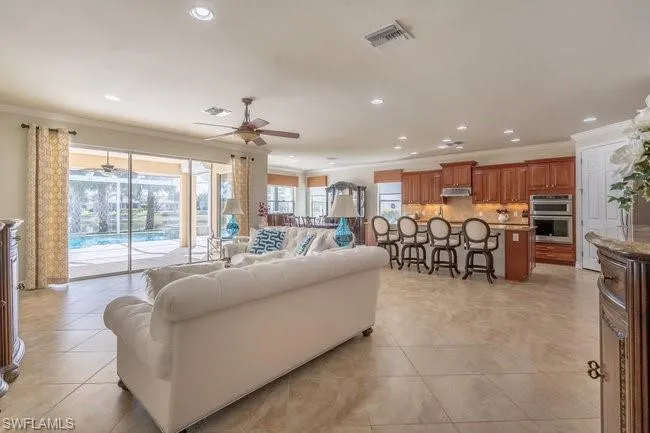 Tiled living room featuring crown molding and ceiling fan