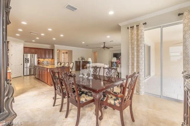 Dining space with crown molding, sink, and ceiling fan