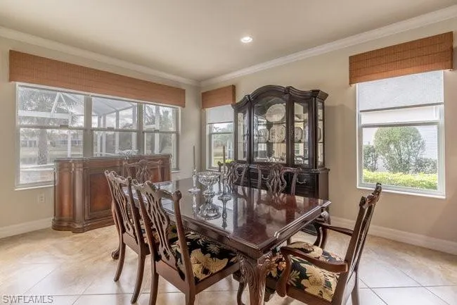 Dining room with ornamental molding and light tile patterned floors