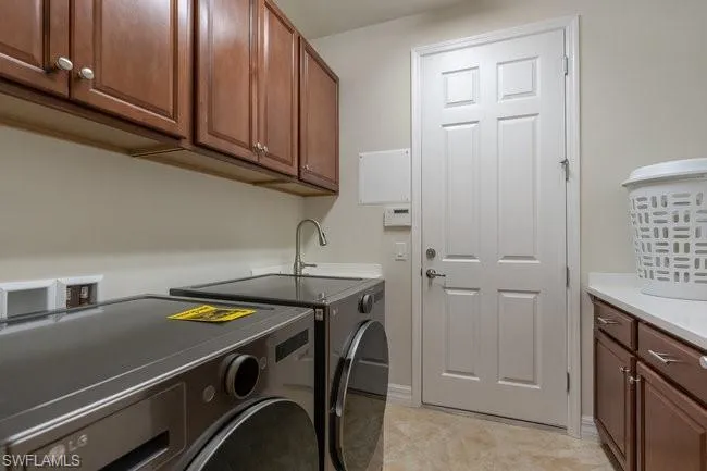 Clothes washing area with separate washer and dryer and cabinets
