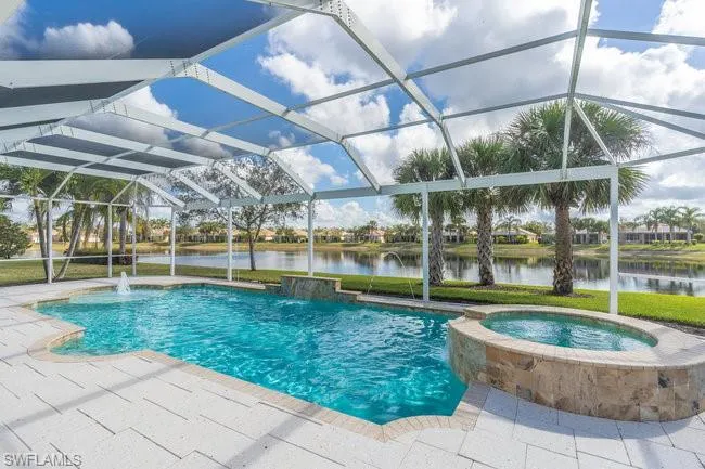 View of swimming pool with an in ground hot tub, a water view, pool water feature, and glass enclosure