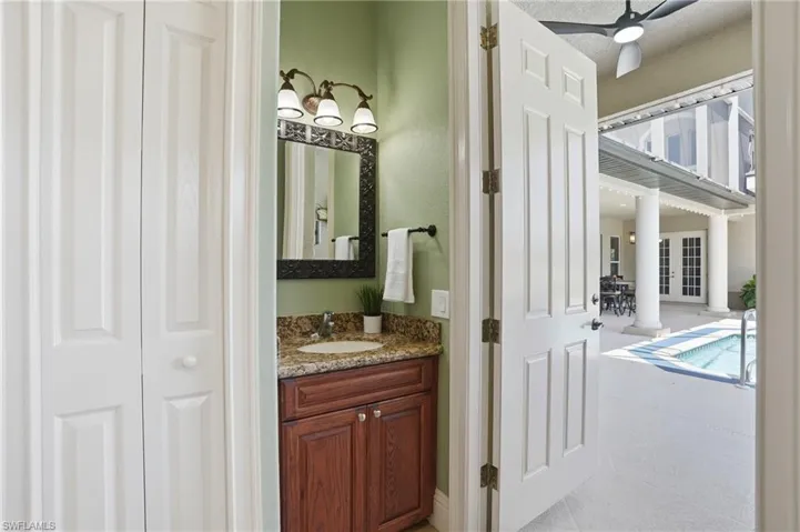 Bathroom vanity featuring a granite countertop, undermount sink, and dark wood cabinetry