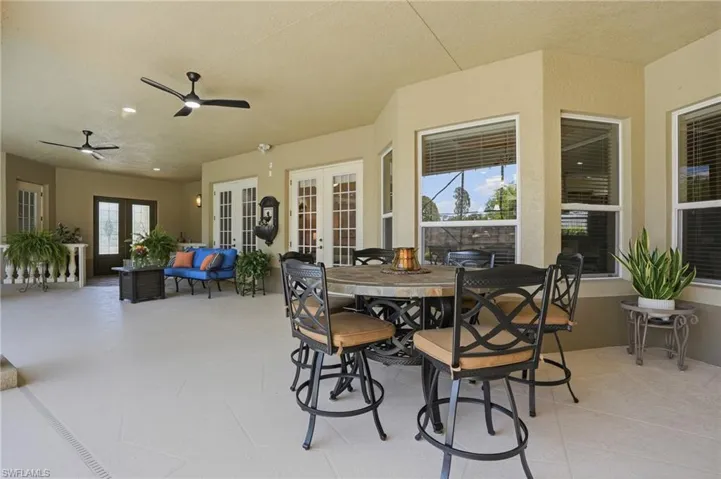 Covered lania featuring multiple ceiling fans, recessed lighting, and a neutral-toned floor