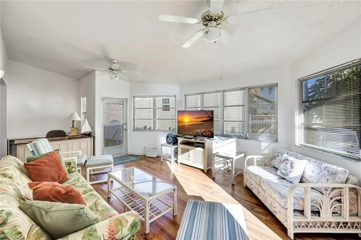 Living area featuring wood finished floors, a textured ceiling, and a ceiling fan
