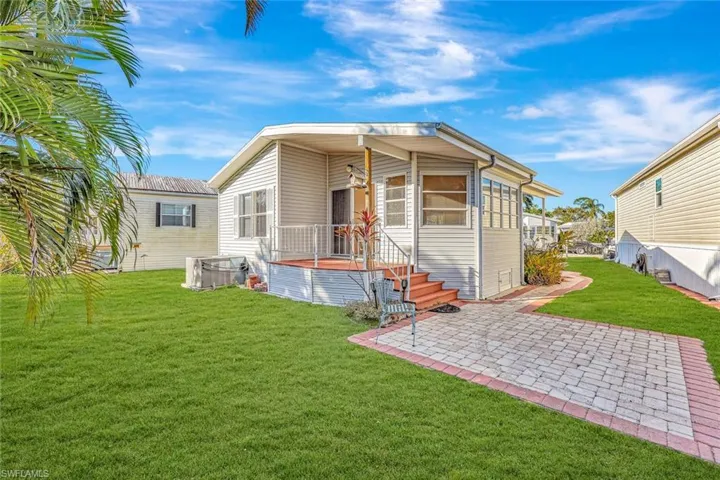 Back of house featuring a lawn and a patio